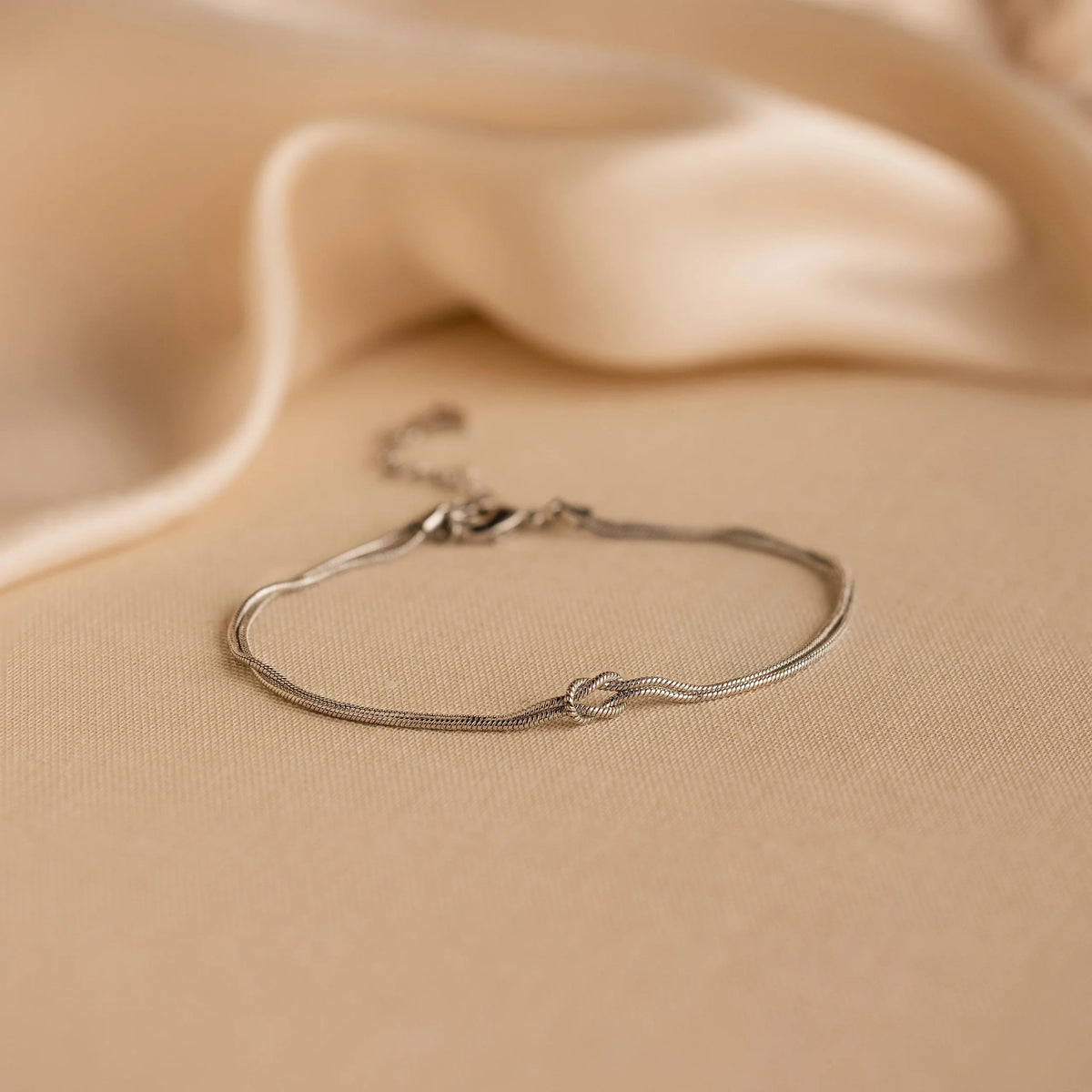 Silver Forever Knot Bracelet on cream fabric