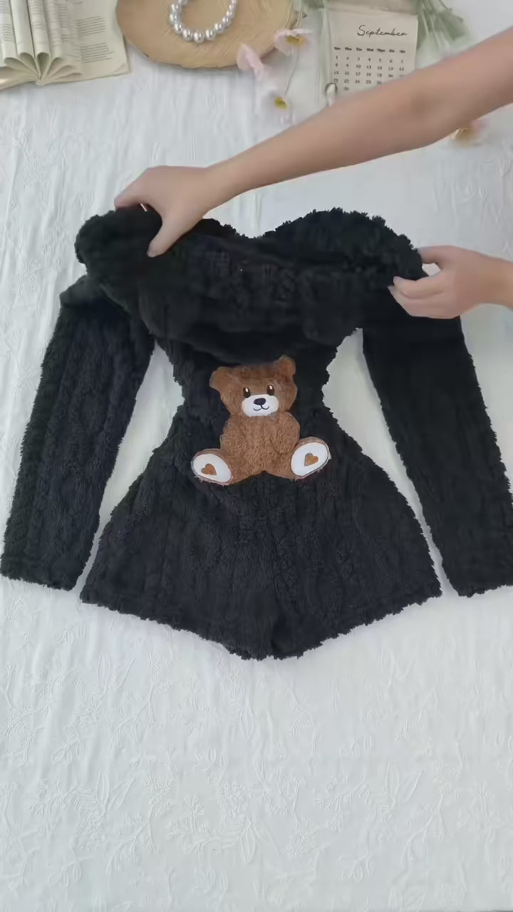 Product demonstration of the Cozy Bear hooded plush romper, showing the front zipper, textured fabric and teddy bear applique on the back.