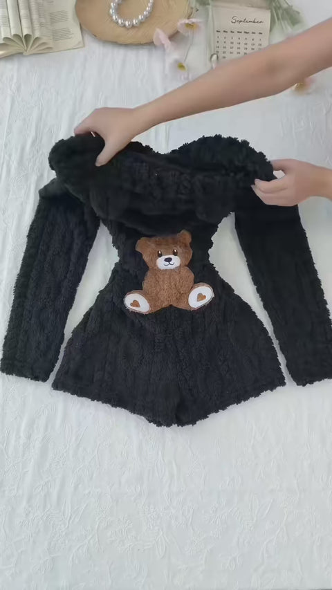 Product demonstration of the Cozy Bear hooded plush romper, showing the front zipper, textured fabric and teddy bear applique on the back.