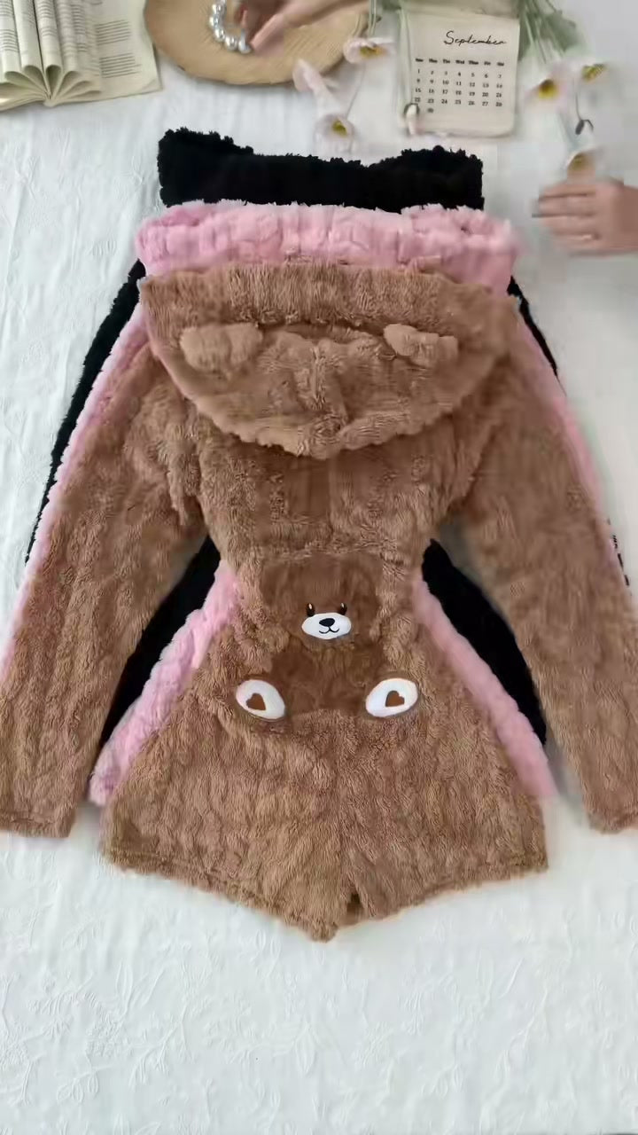 Brown Cozy Bear hooded plush romper, original video still showing the back teddy-bear patch and bear-ear hood.