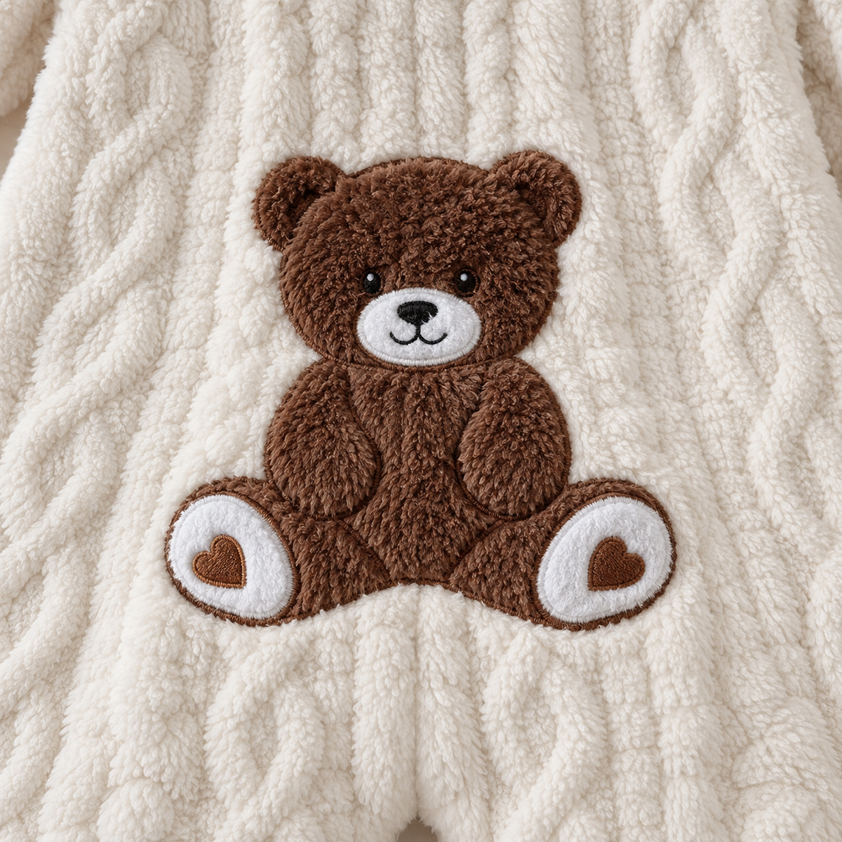 Close-up of the brown teddy bear applique on the back of the white Cozy Bear romper